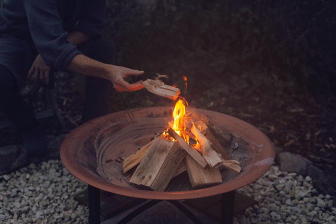 Person Holding Brown Wooden Round Tray With Fire