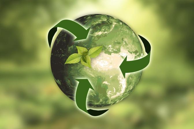 Earth in green surrounded by the arrows of the recycle symbol with a sprout