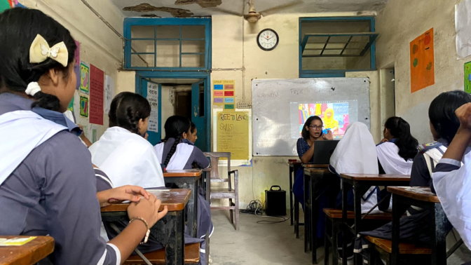 Students listening to a teacher speaking in a classroom in Bangladesh