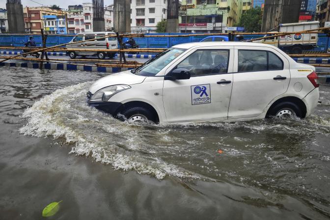 white car driving through a flooded street