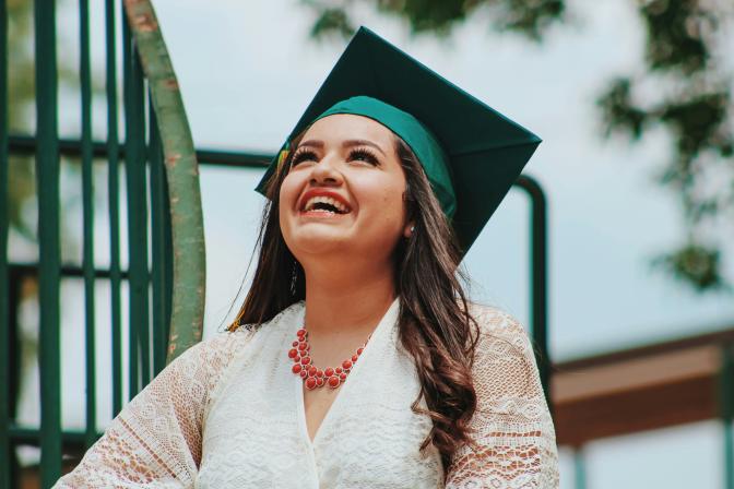 A graduate looking up and smiling