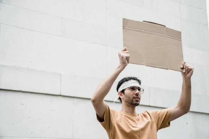 a man holding a blank cardboard