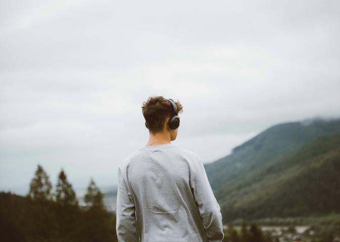 man with a headphone standing on a hillside