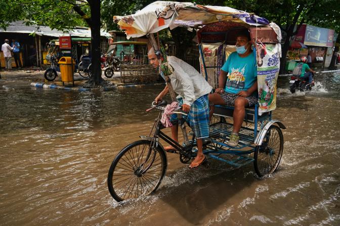 a person riding a bicycle through a flooded street