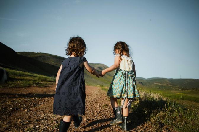 two girls walking on a field