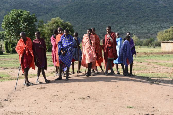 group of people standing on a grass field