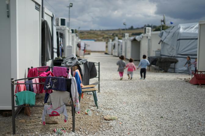 Syrian children walking through a refugee camp