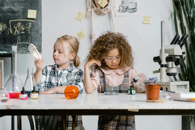 Two young students conducting STEAM experiments in a classroom